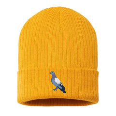 The Roberto Lugo Pigeon Beanie is a bright yellow, ribbed knit hat with a folded brim and an embroidered pigeon graphic on the front, inspired by artful heritage and featured at The Henry Ford Museum.
