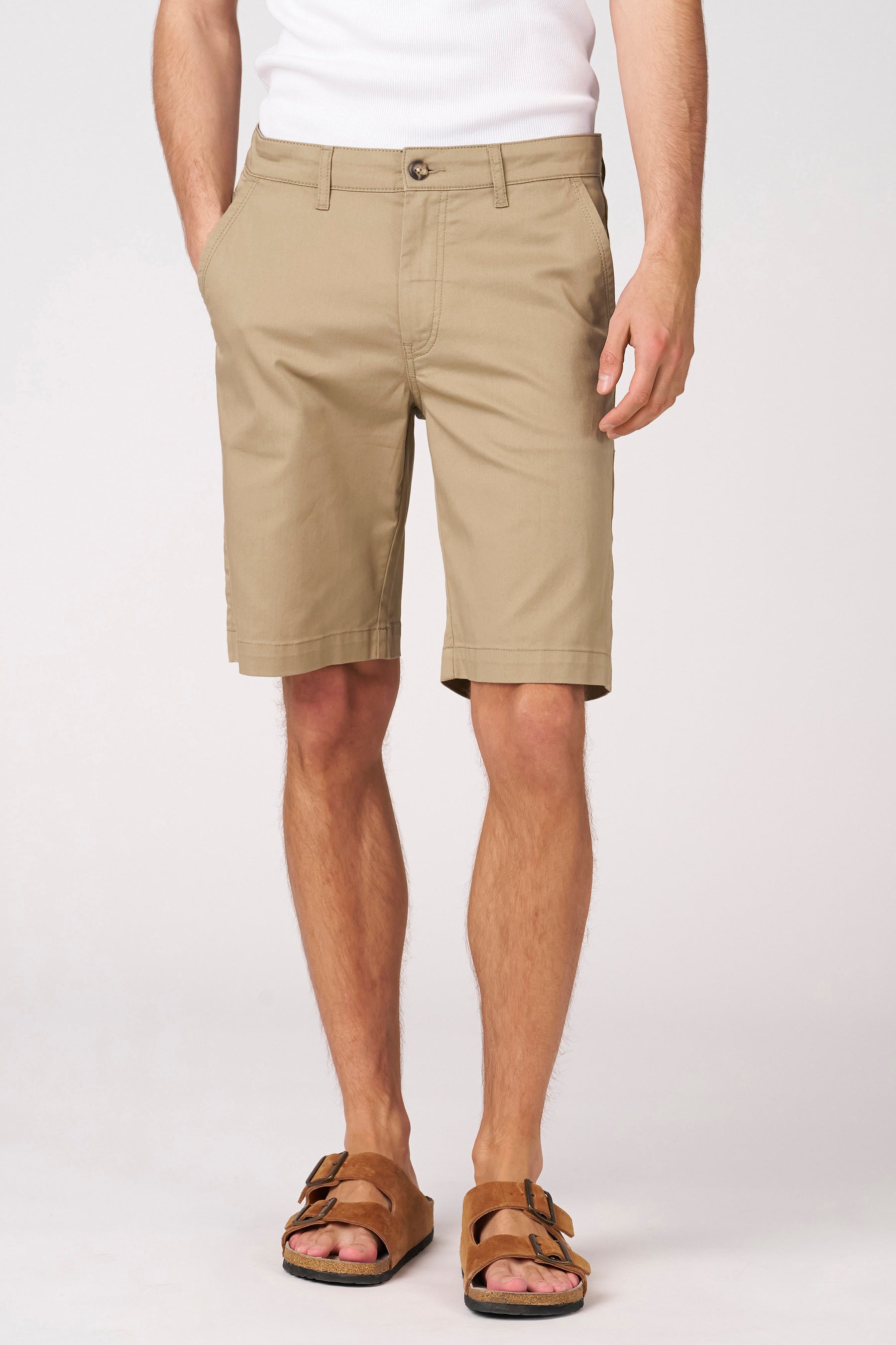 Short beige de Bruce & Butler, avec poches arrière et une étiquette de marque en cuir sur la ceinture.