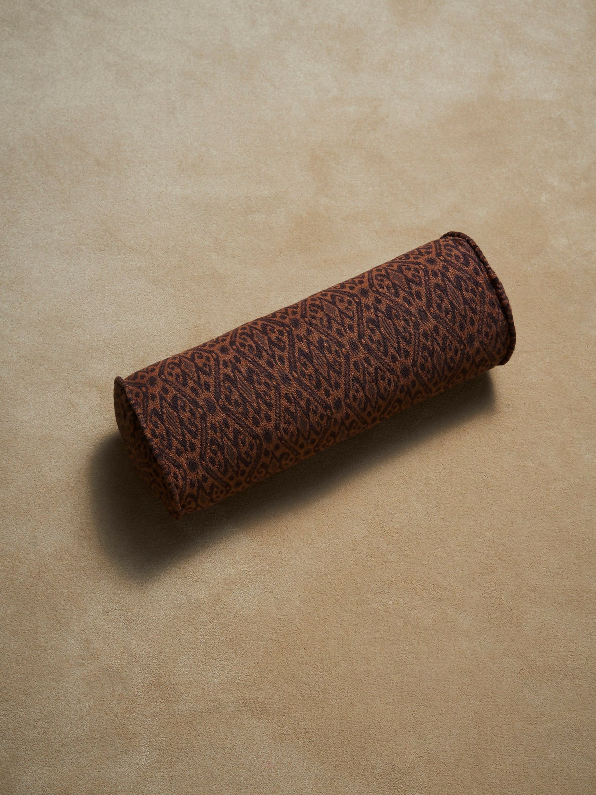 Brown cylindrical pillow with a leopard print pattern on a beige background,  available  to buy on the-salon.com. SALON curates the finest , unique, handmade pieces from the interior industry's best makers and brands. Shop luxury furniture, lighting, rugs, art, antiques and vintage pieces and accessories from SALON interior designed rooms.