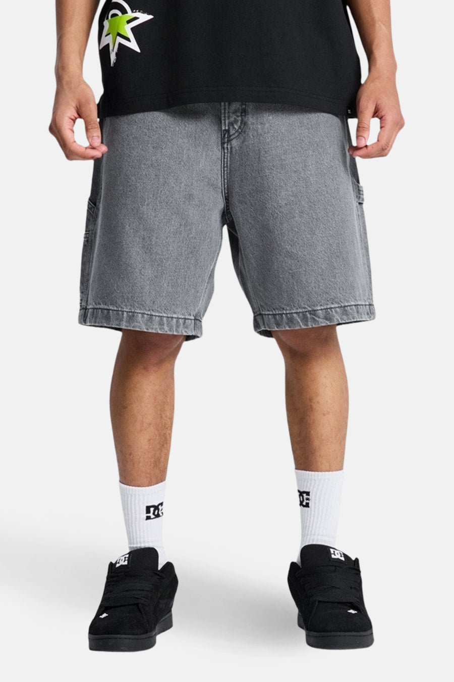 Grijze denim jeansshort van DC SHOES, met witte sokken en zwarte schoenen.