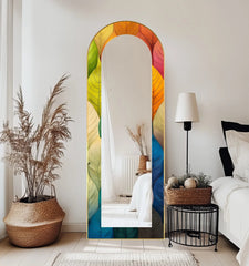 Botanically inspired decorative mirror with an arched, colorful leaf pattern accentuating the artistic edge and gold-toned borders.