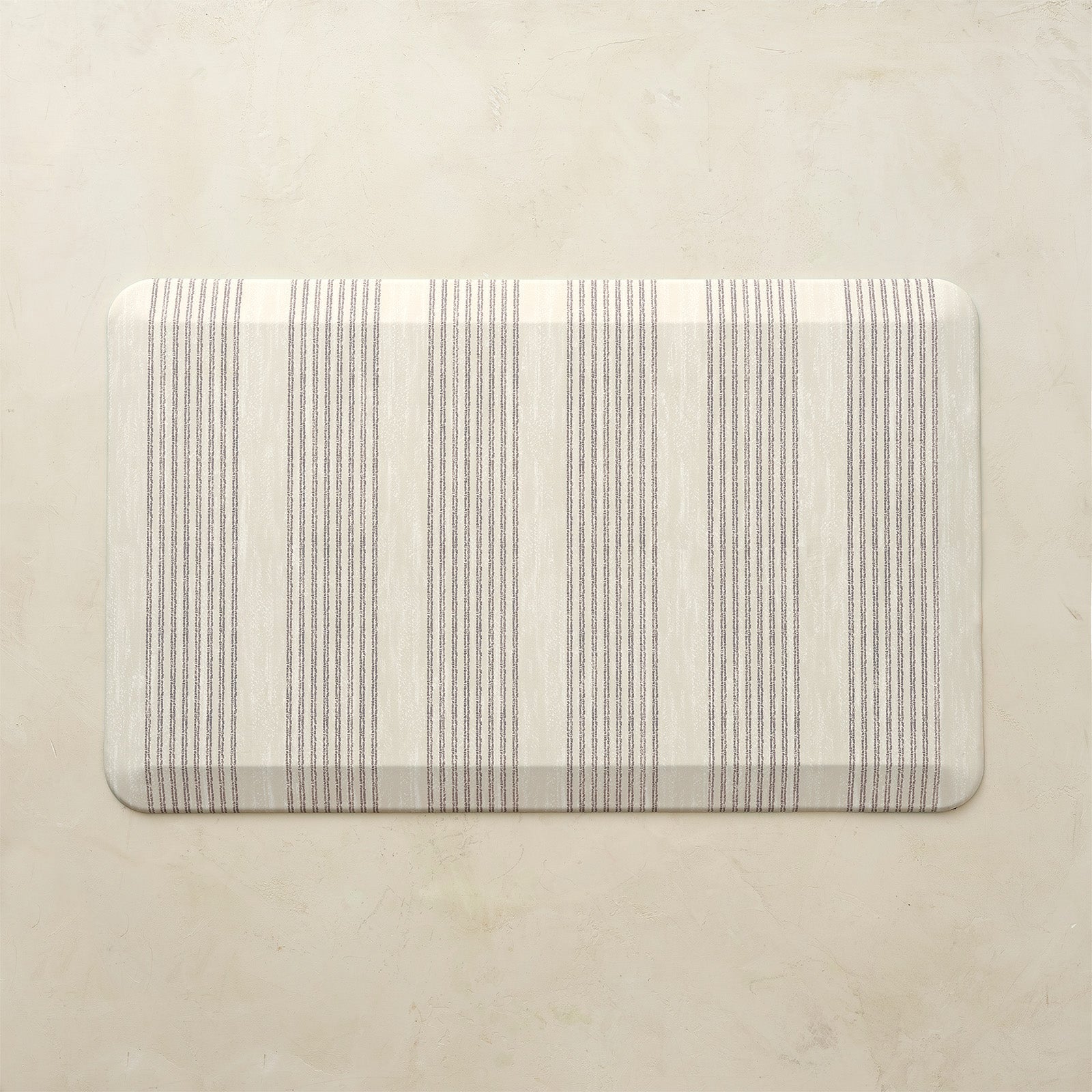 Rectangular kitchen mat with neutral striped pattern on a beige background