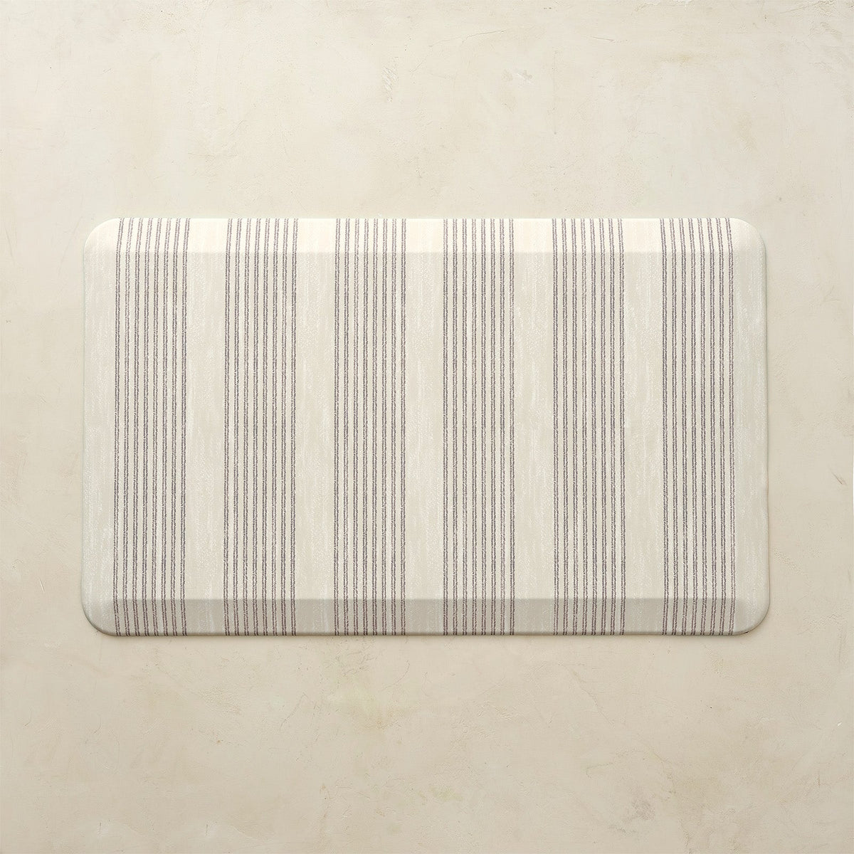 Rectangular kitchen mat with neutral striped pattern on a beige background