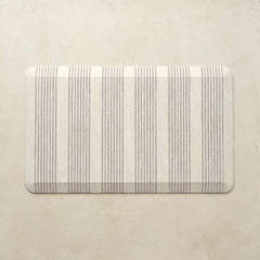 Rectangular kitchen mat with neutral striped pattern on a beige background