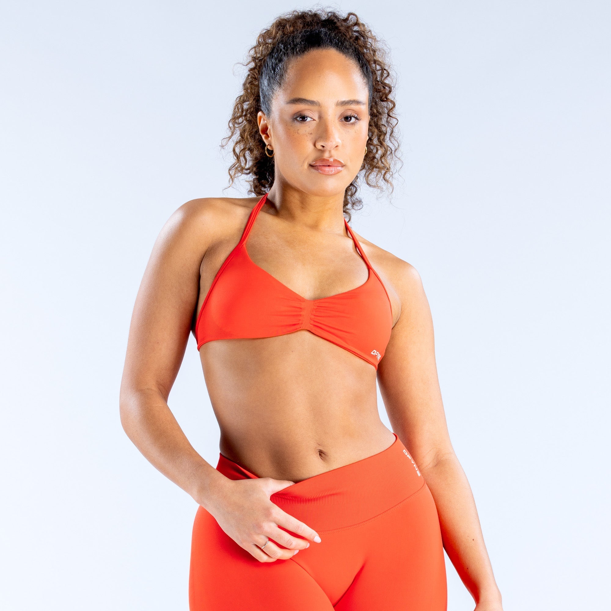 Orange strappy sports bra with ruched bust and thin racerback straps