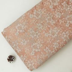 Pink fabric with white floral embroidery on a white background