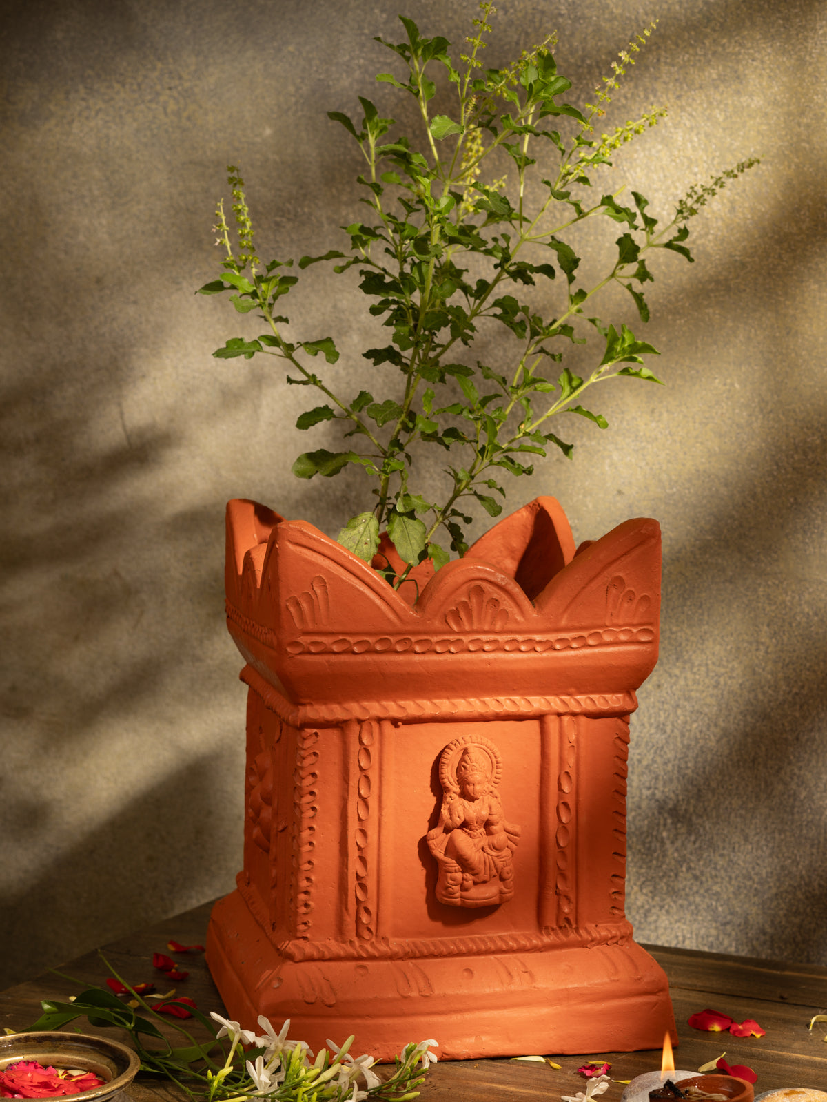 Handcrafted terracotta Tulsi Pot with Tulsi plant in traditional Vrindavan style, placed in a pooja setup with natural lighting and sacred decor.