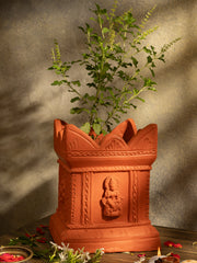 Handcrafted terracotta Tulsi Pot with Tulsi plant in traditional Vrindavan style, placed in a pooja setup with natural lighting and sacred decor.