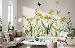 Vintage botanical mural wallpaper in soft yellow and green, with modern sofa, armchair, and decor.