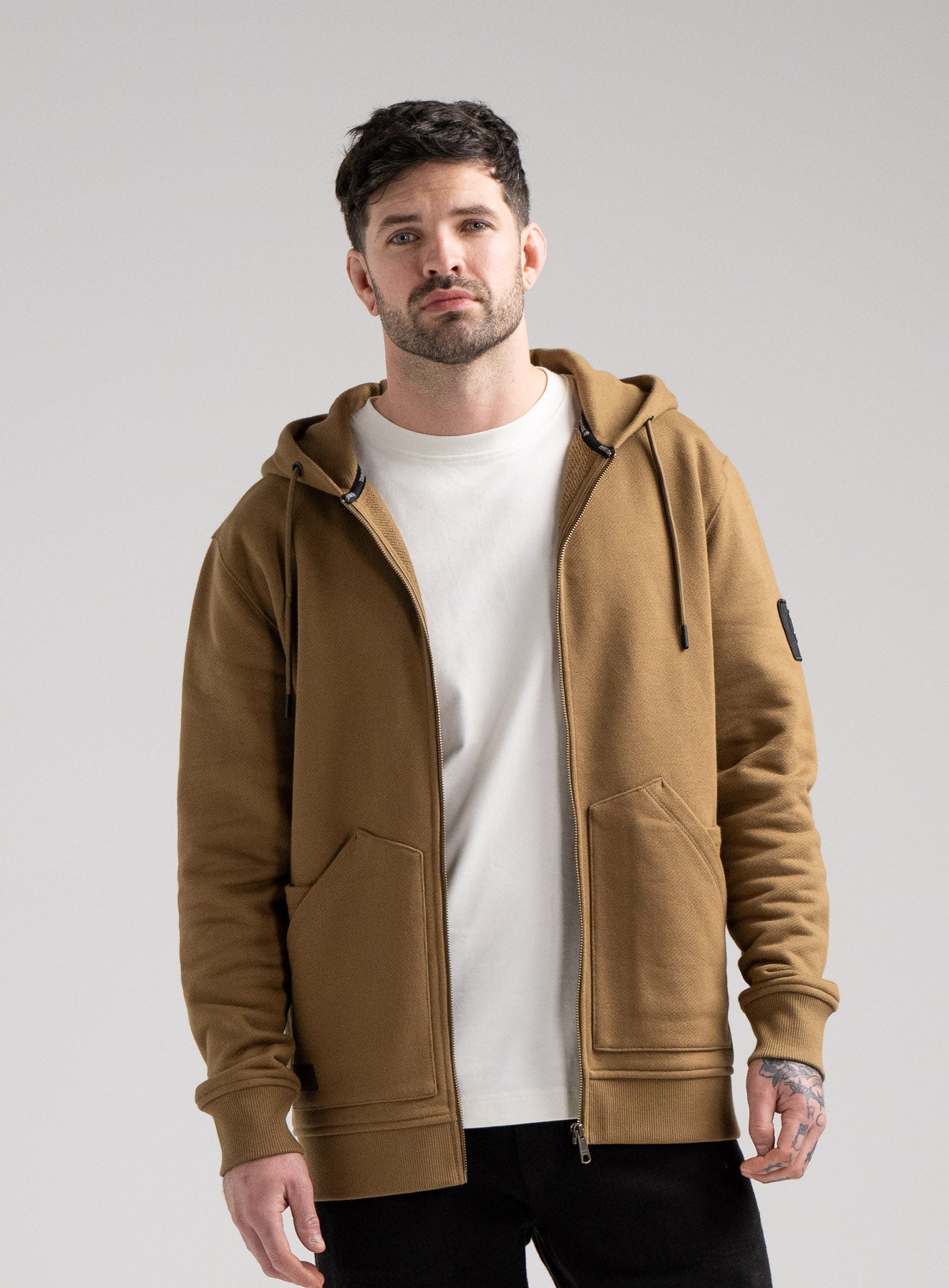 Bernie Is 6ft And Wears Size: M | Hem Studio Image Of Model Wearing Dissident Zipped Hoody In Coyote Brown (SS Model)