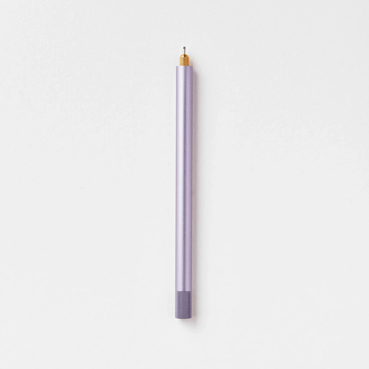 Tom's Studio Lumos Pro Single in Lilac (pale purple), fineline tip exposed, cap posted, on textured paper